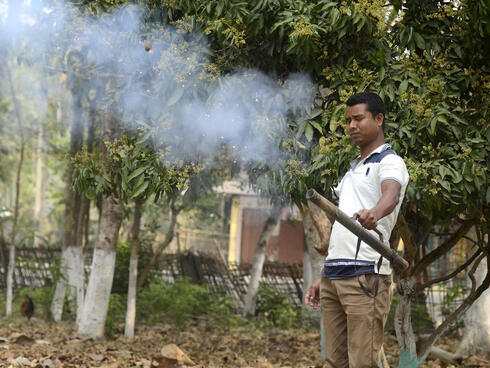 Man holding metal tube with smoke rising