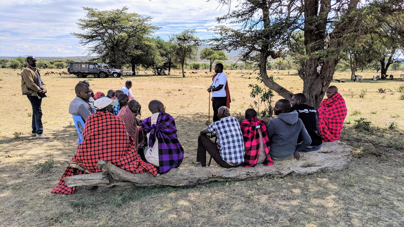 People gather under a tree to discuss data for the Climate Crowd