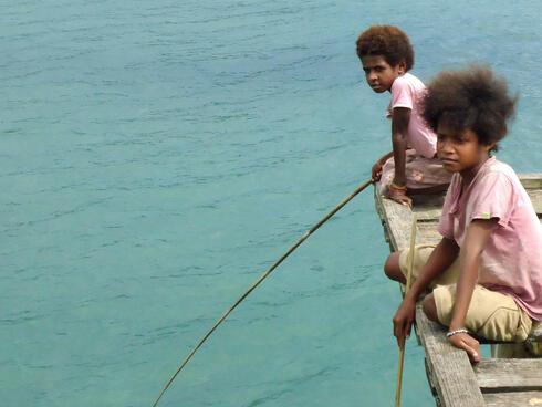 Boys on a dock in Bird's Head Seascape, West Papua, Indonesia