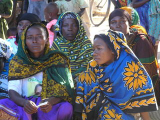 Sijali Kipuli in a VICOBA introductory meeting attentively listening to the facilitators in 2006.