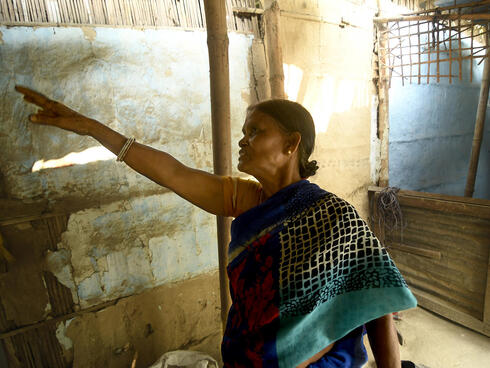 Woman pointing to house wall