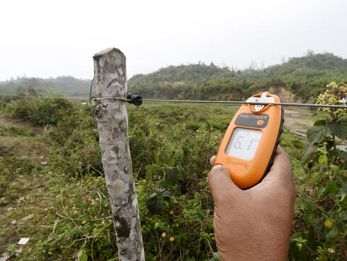 Using a tool to measure current on wire fence