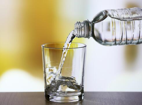 Bottled water pouring into glass